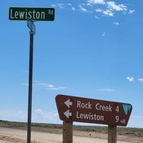 Lewiston Rd street sign above a brown BLM sign: Rock Creek 4, Lewiston 9